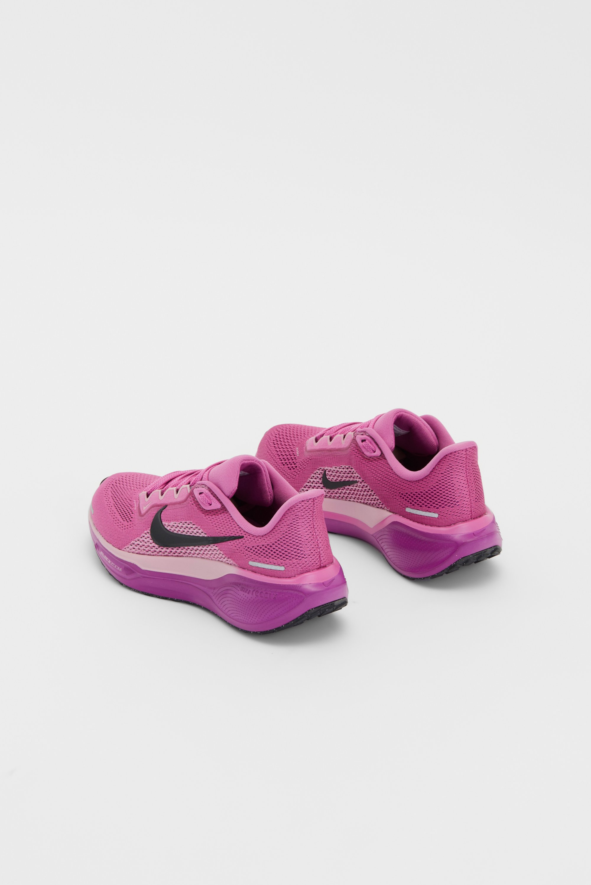 Pink Nike running shoes with black swoosh, featuring a breathable mesh design and lightweight cushioning, positioned against a white background.