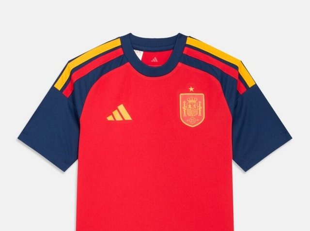 Piros focimez tengerészkék ujjal, sárga és piros csíkokkal a vállakon, a spanyol válogatott címerével és sárga Adidas logóval a mellkason.