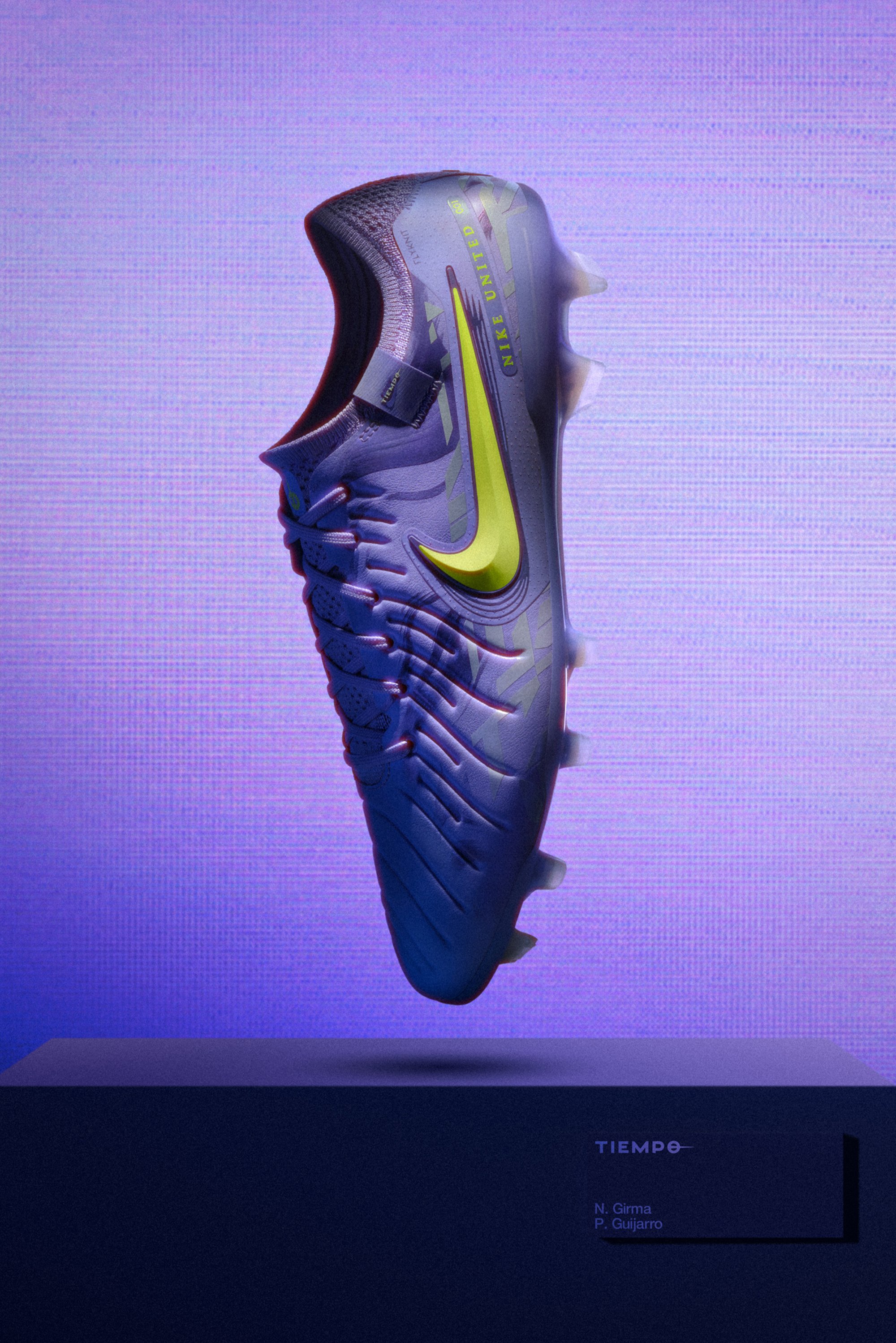 A vibrant purple Nike soccer cleat with a yellow swoosh, displayed against a gradient background, resting on a dark pedestal with labels.