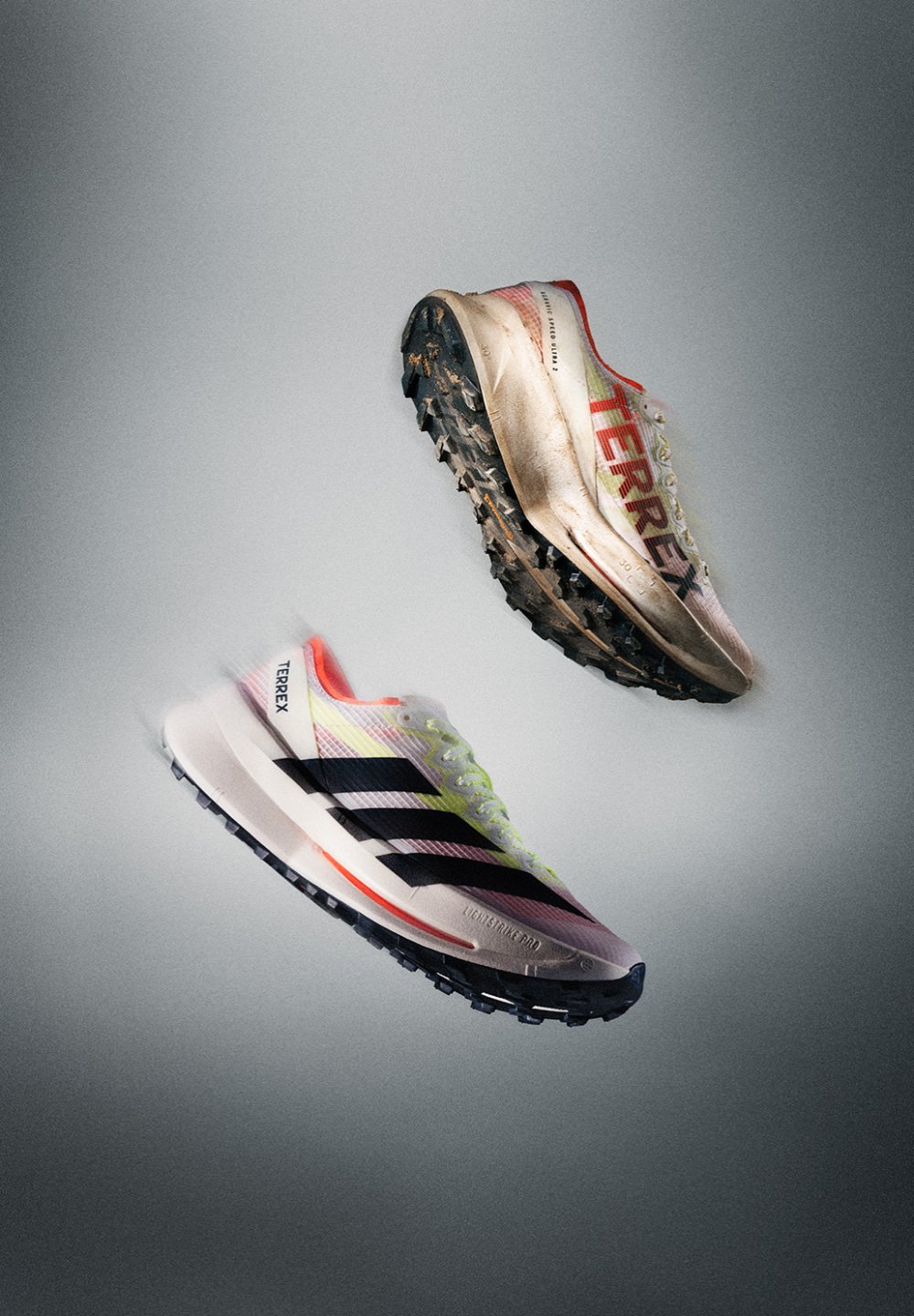 To flytende Adidas Terrex terrengløpesko, en ren og en gjørmete, som viser mønsteret på sålen og side-logoene.