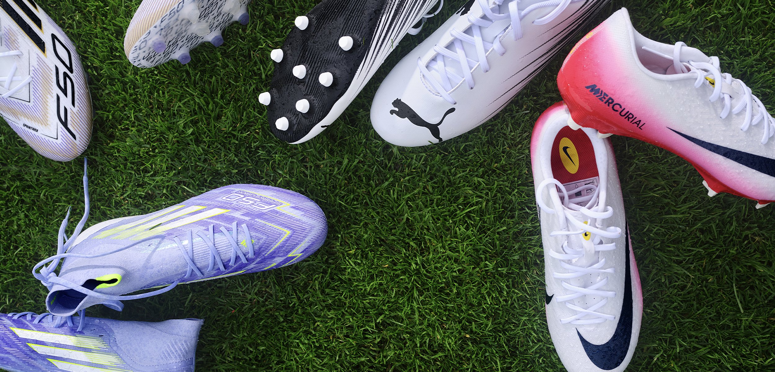 Pięć par kolorowych korków do piłki nożnej ustawionych w kształcie okręgu na zielonej trawie, z takimi markami jak Puma i Nike.