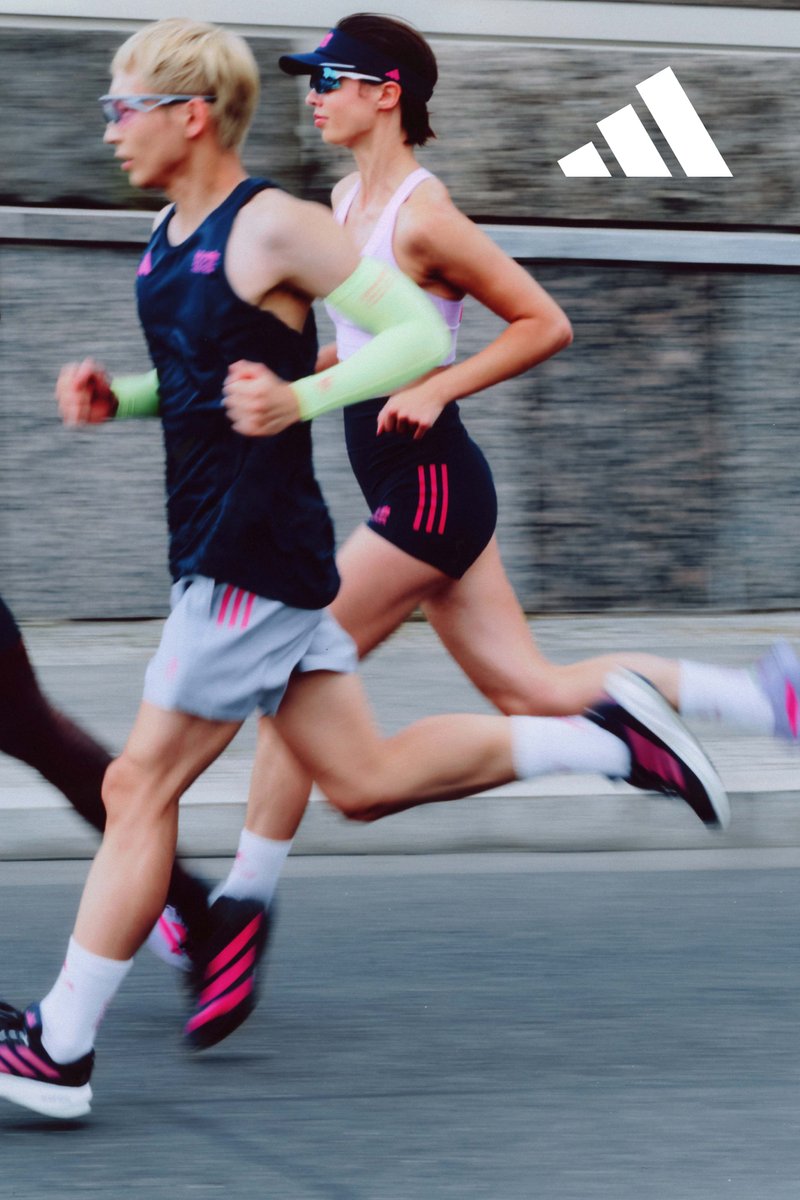 Three runners in motion on a pavement. They are wearing athletic gear: neon green, dark blue, and pink outfits, complete with sunglasses and running shoes.