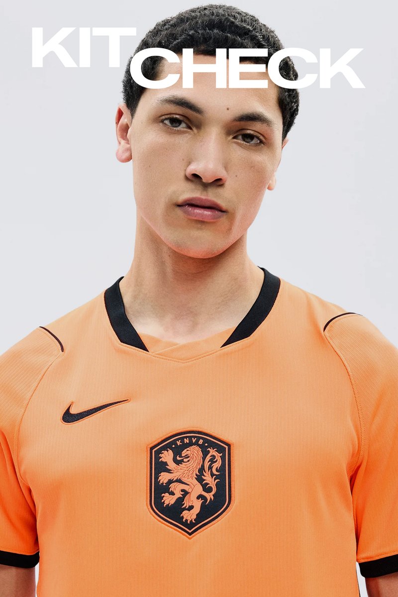 Jeune homme portant un maillot de football orange des Pays-Bas avec bordure noire et emblème de lion, texte "KIT CHECK" au-dessus de sa tête.