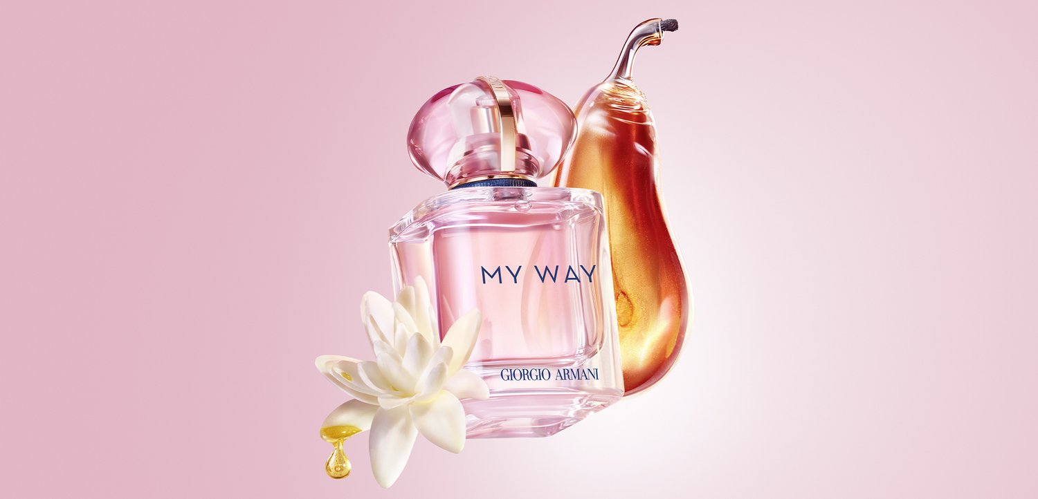 Bottiglia di profumo Giorgio Armani My Way con liquido rosa, fiore bianco, pera dorata e una goccia su uno sfondo rosa tenue.
