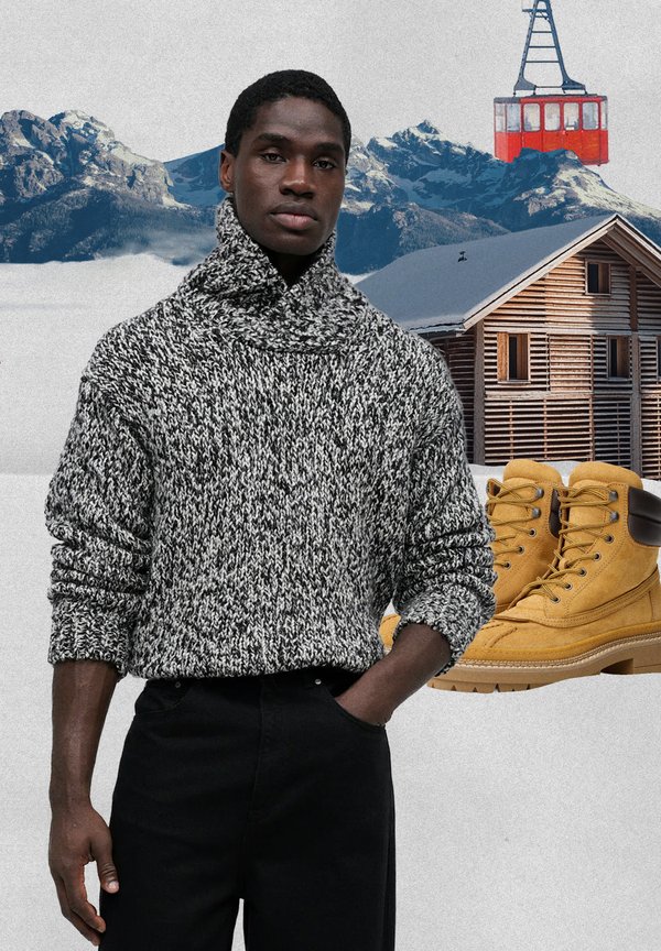 Chunky grey and white knitted jumper with a high collar, paired with black trousers; yellow sturdy lace-up boots in the foreground.