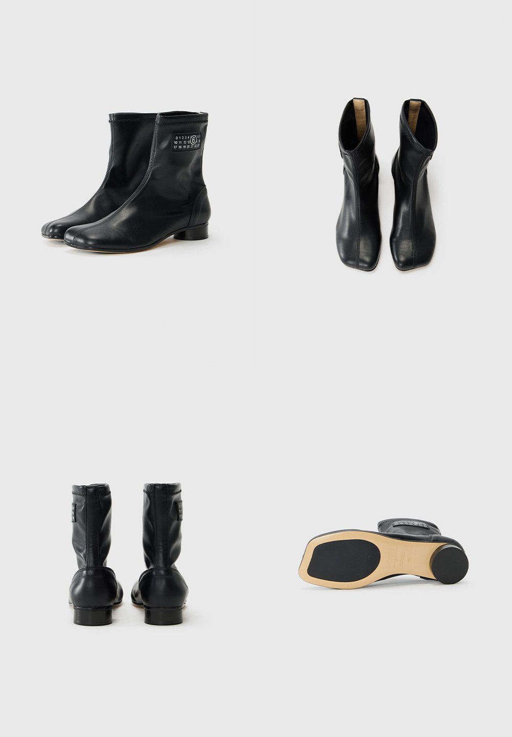 Sorte ankelstøvler lavet af glat læder, med en lav hæl, rund tå og lynlås lukning med branding på siden.