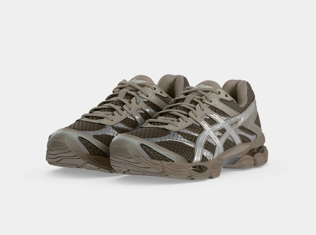 Paire de chaussures de course athlétiques marron et grises avec tissu en mesh, design à lacets et semelles en caoutchouc texturées sur un fond uni.