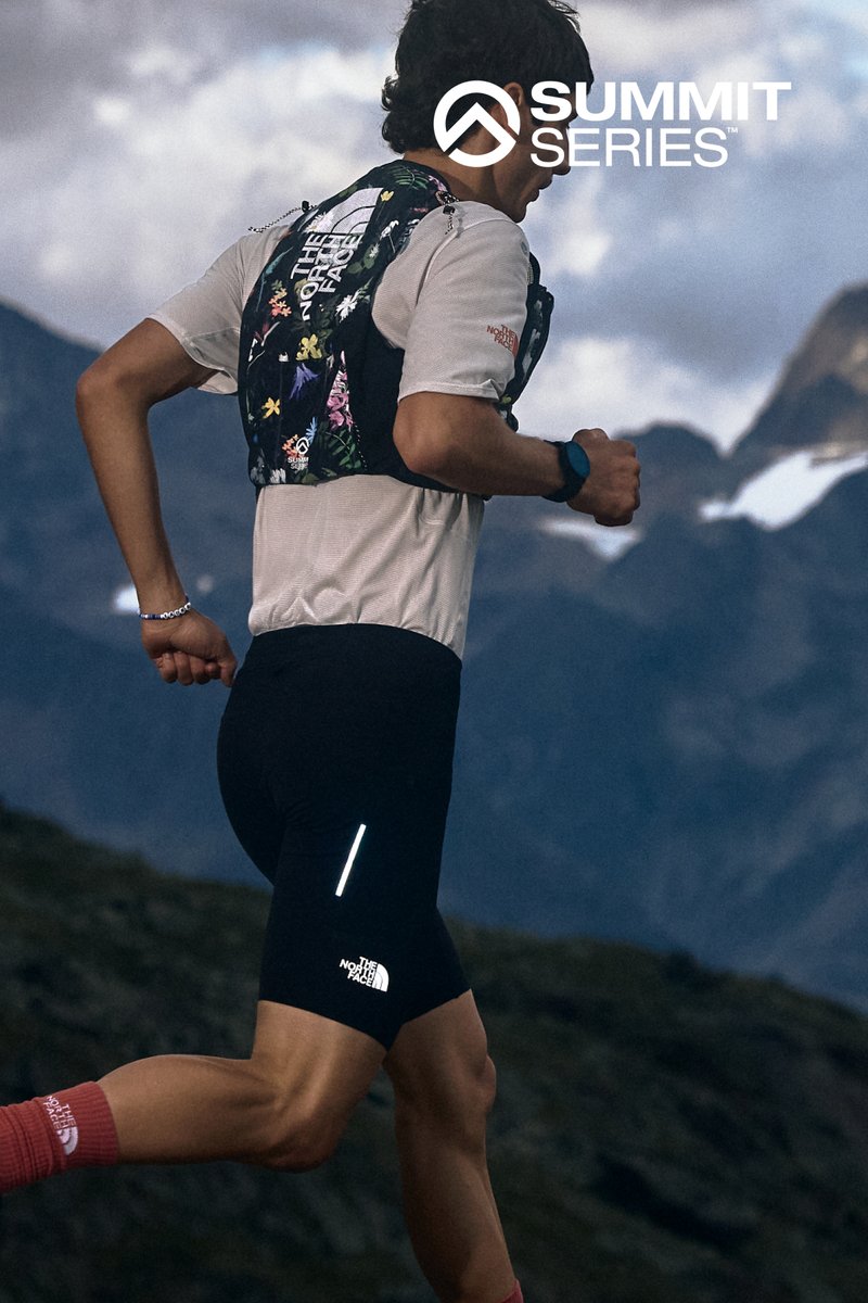 Ropa de running que presenta un short negro ajustado y un chaleco de hidratación con un patrón floral. Los acentos reflectantes mejoran la visibilidad en condiciones de poca luz.