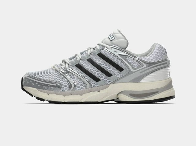 Ténis de corrida em rede branca e cinzenta com riscas pretas, sola almofadada e design com atacadores, mostrado de lado.