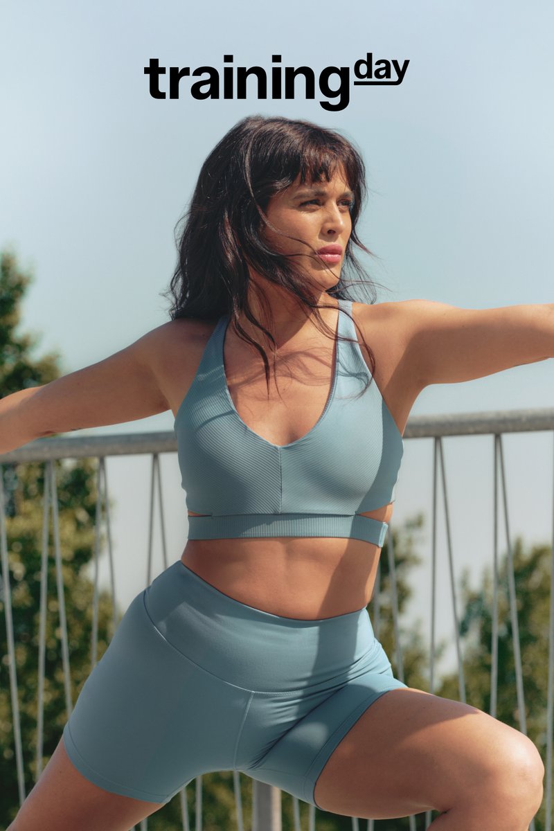 Lichtblauwe sportoutfit, bestaande uit een sportbeha met diepe V-hals en hooggewaste shorts, met geribbelde textuur en uitsneden.