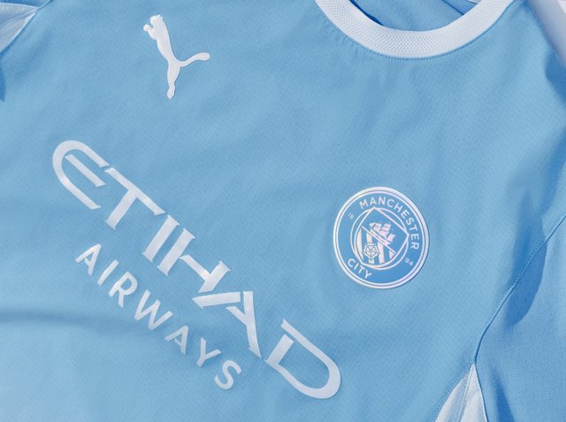 Hellblaues Manchester City Fußballtrikot mit weißem Puma-Logo, Vereinswappen und Etihad Airways Sponsor-Text auf der Vorderseite.