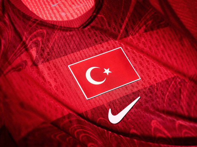 Rotes Sporttrikot mit der türkischen Flagge mit weißem Halbmond und Stern über einem weißen Nike-Swoosh-Logo.