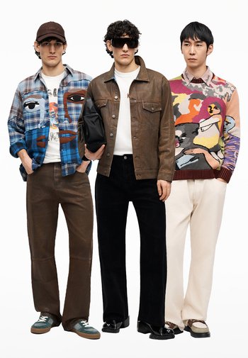 Három férfi áll egymás mellett, művészi mintás felsőket viselve: kockás ing arcnyomattal, barna bőrkabát és színes, absztrakt pulóver.