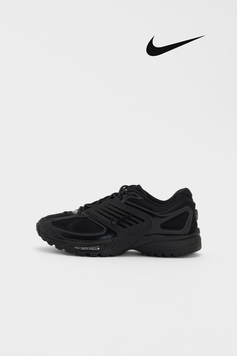 Black Nike sneaker displayed against a white background, featuring a textured upper and prominent logo, emphasizing sporty design elements.