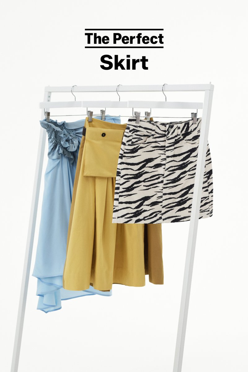 Three skirts hanging on a white rack: blue ruffled, mustard yellow with large pocket, and black-and-white animal print short skirt.