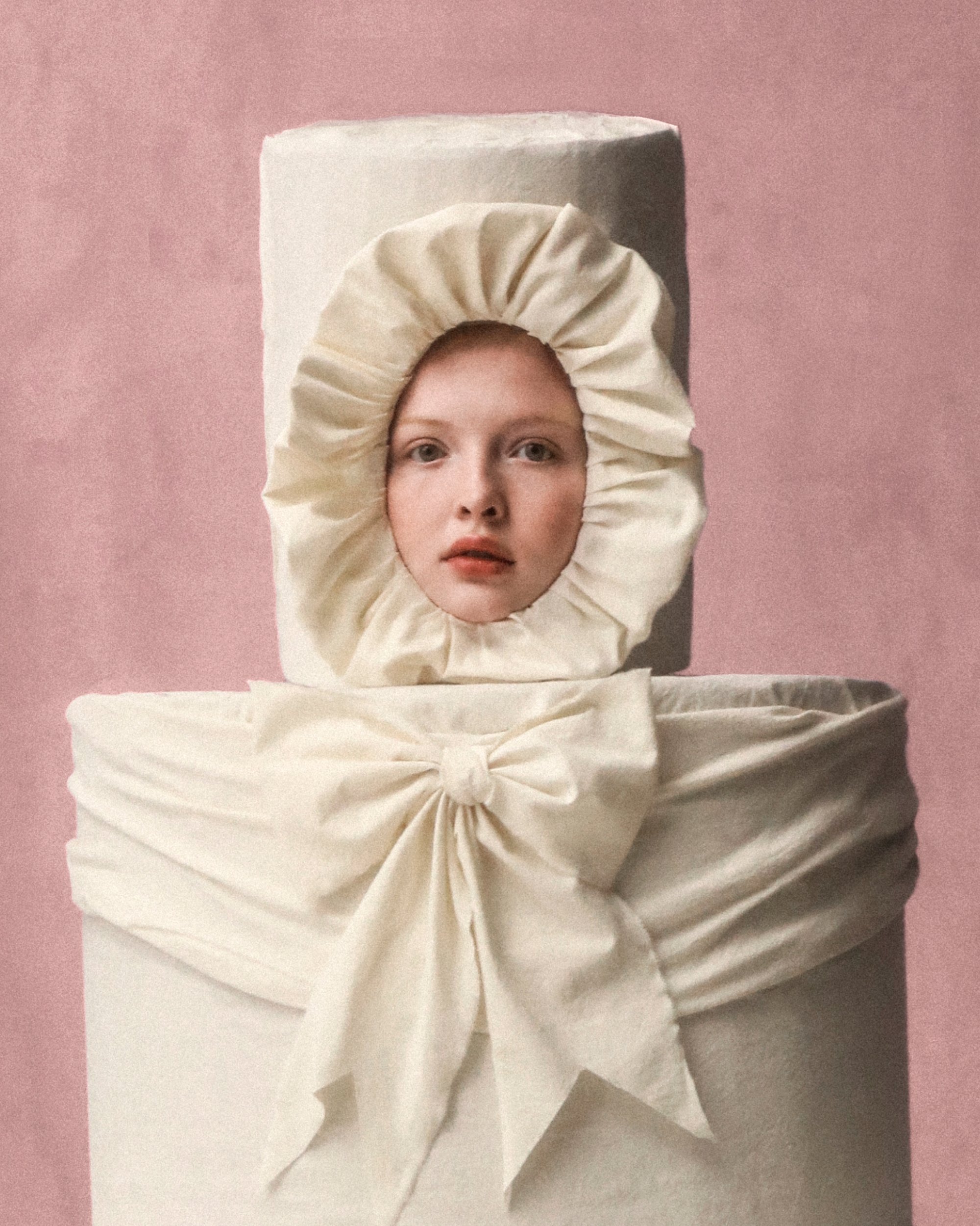 A young woman with a serene expression peers through a round, ruffled fabric opening, framed by a soft, neutral background.