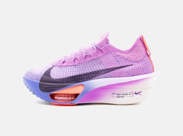 Ανοιχτό μοβ παπούτσι τρεξίματος Nike με μαύρο swoosh, πορτοκαλί λεπτομέρειες και παχύ λευκό πάτο με επιγραφή "Air Zoom" και "Road Racing AF."