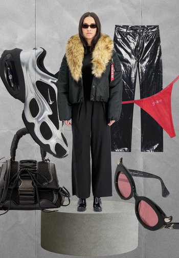 Schwarze Steppjacke mit Kunstpelzkragen, glänzende schwarze Vinylhose, futuristische Sneaker, schwarze Netz-Handtasche und ovalförmige Sonnenbrille.