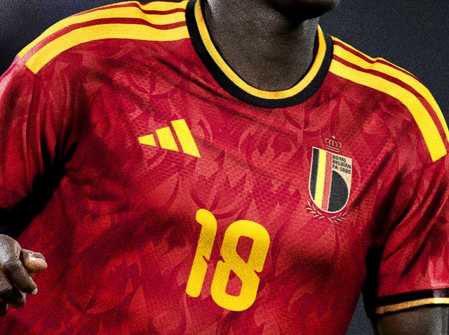 Rotes Fußballtrikot mit gelben Streifen, Nummer 18, Adidas-Logo und dem Wappen der belgischen Nationalmannschaft auf der Brust.