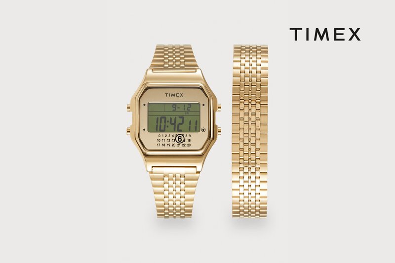 Digitale Uhr in Goldton mit achteckigem Gehäuse, LCD-Anzeige mit Uhrzeit und Datum sowie einem flexiblen Gliederarmband. Einfaches, elegantes Design.