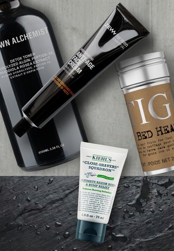 Quatre produits de soin et de grooming disposés sur une surface texturée : tonique détox, crème anti-âge pour le visage, stick pour les cheveux et crème apaisante après-rasage.