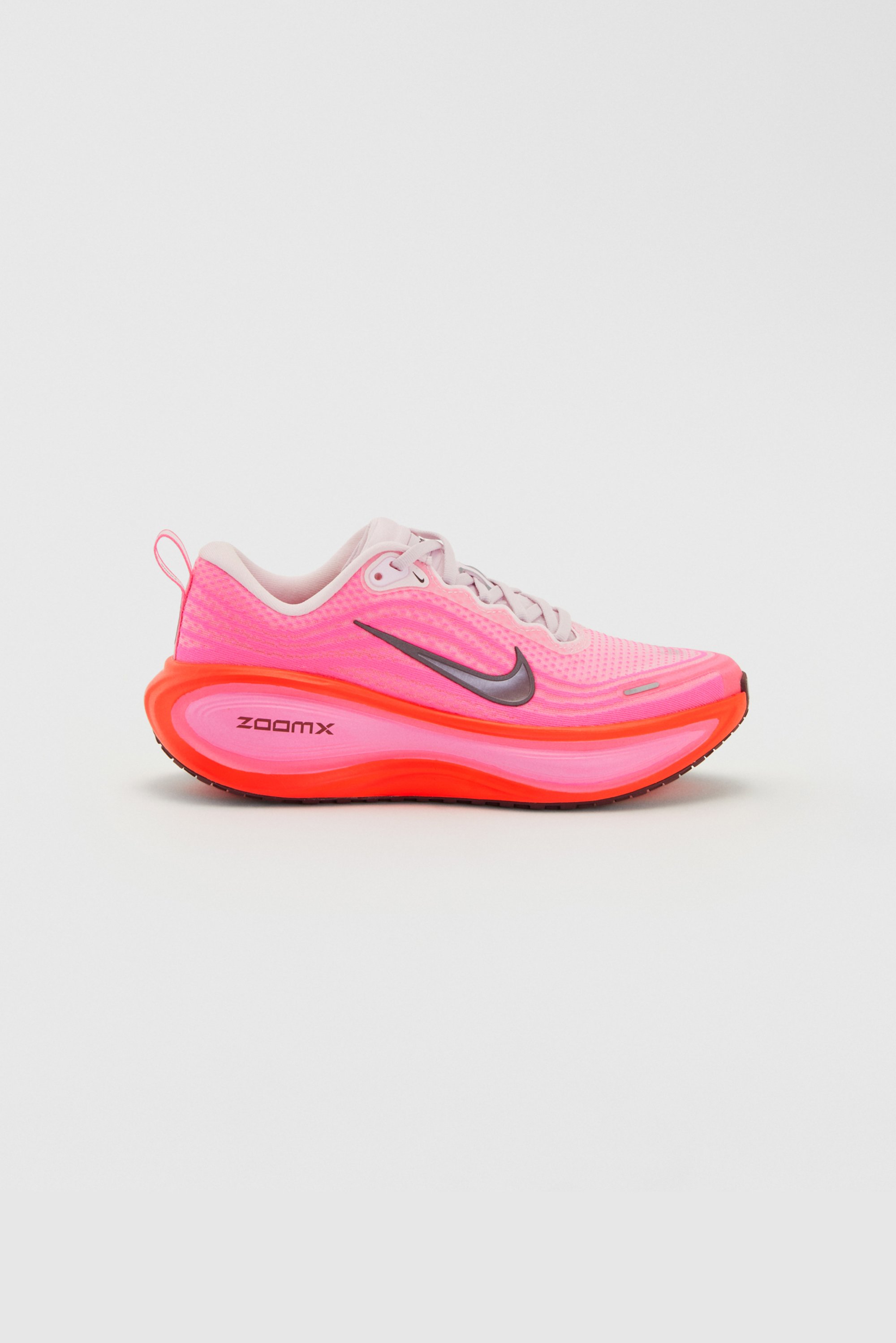 Nike hardloopschoenen met een ademende roze mesh bovenkant, zilveren accenten en een opvallende rode en roze dempende zool gemarkeerd met "ZOOMX."