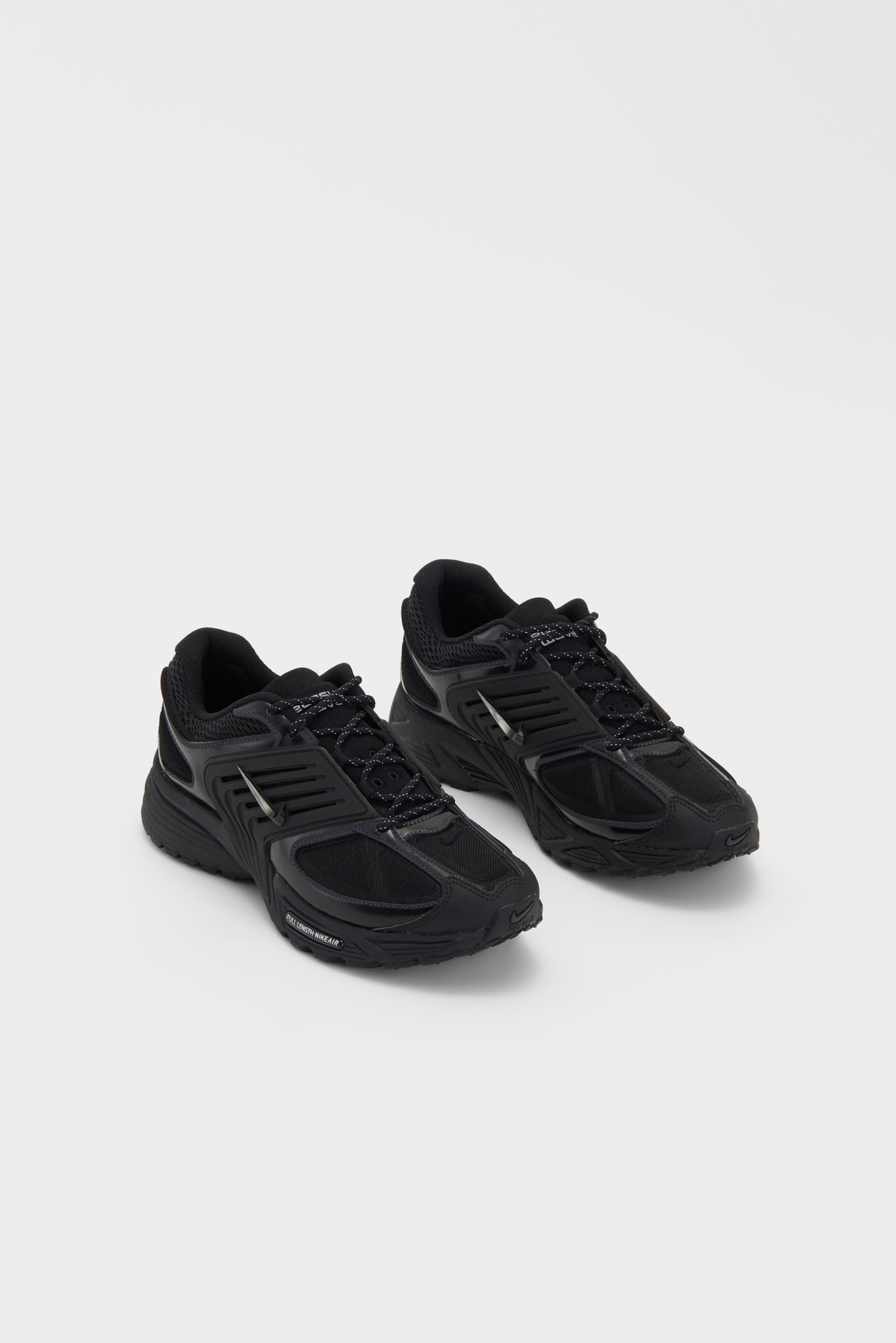 Zwarte sportschoenen met gaaspanelen en veters, getoond op een witte achtergrond. Het ontwerp benadrukt comfort en sportfunctionaliteit.