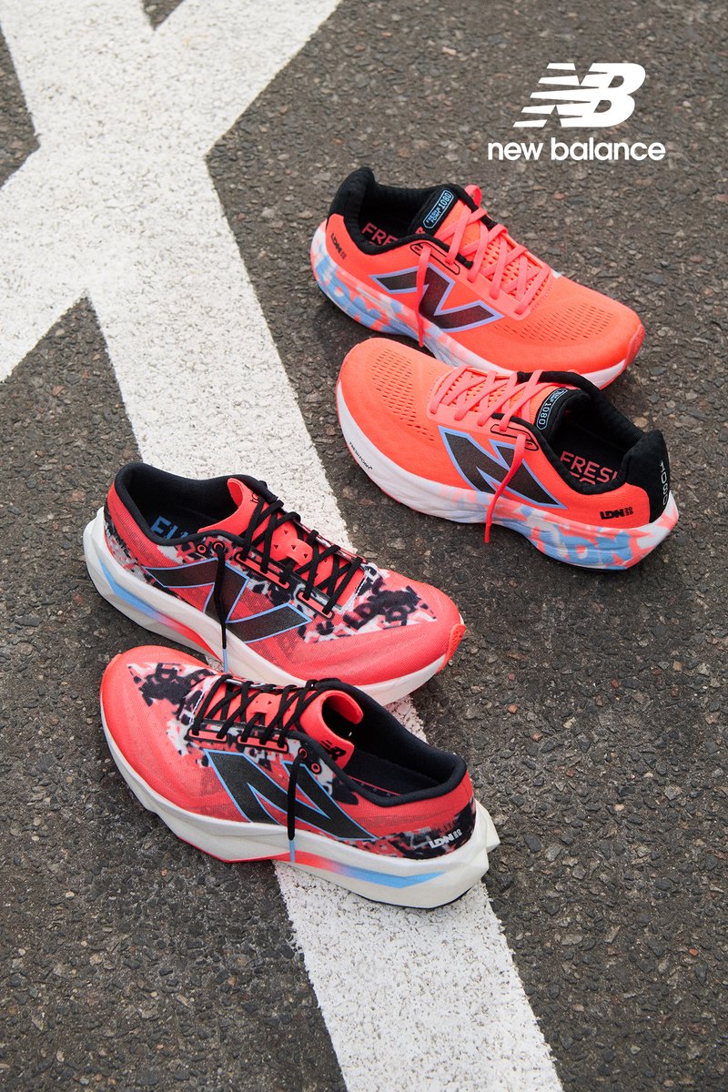 Three pairs of New Balance running shoes in vibrant red and black arranged on a textured asphalt surface, with a white painted line nearby.