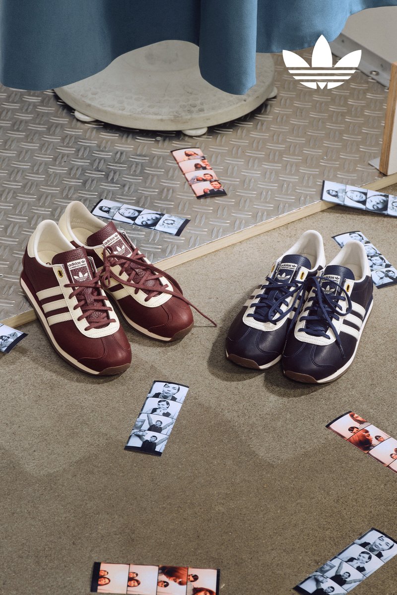 Two pairs of vintage Adidas shoes in burgundy and navy are displayed on a textured surface, surrounded by scattered black-and-white photo strips.