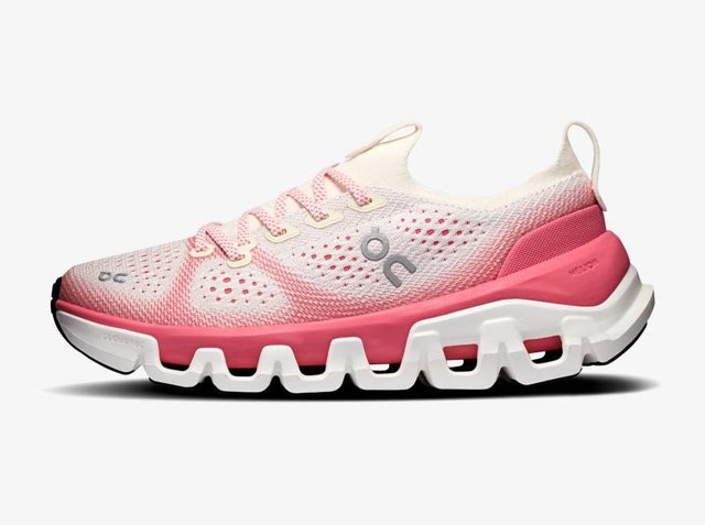 Lichtroze en witte sportschoen met mesh bovenwerk, roze veters, dikke gesegmenteerde witte zool en klein grijs logo aan de zijkant.