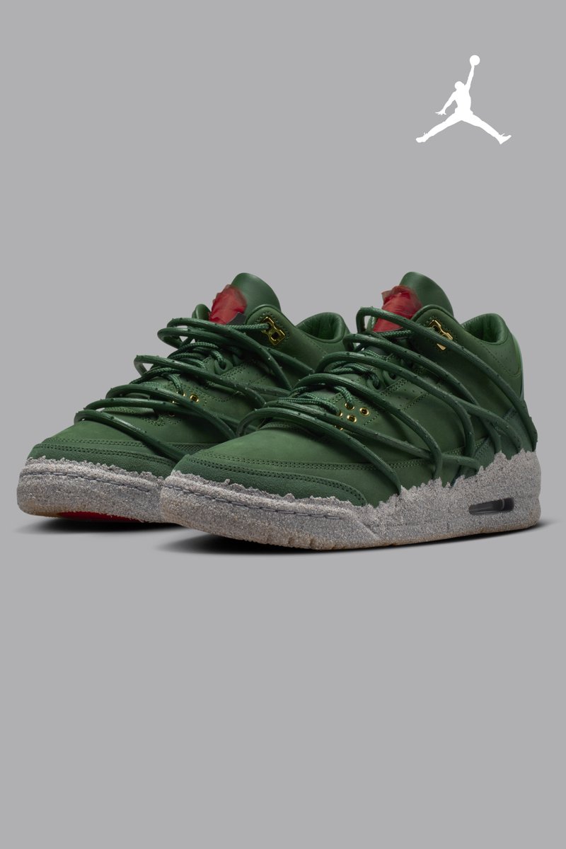 Paar grüne Turnschuhe mit grob strukturierten grauen Zwischensohlen, umwickelten Schnürsenkeln, goldenen Ösen und roten Zungenakzenten auf grauem Hintergrund mit weißem Jumpman-Logo.