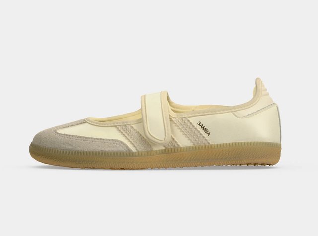 Baskets beige et crème profil bas avec une seule bride en Velcro et une semelle en gomme, étiquetées "SAMBA" sur le côté.