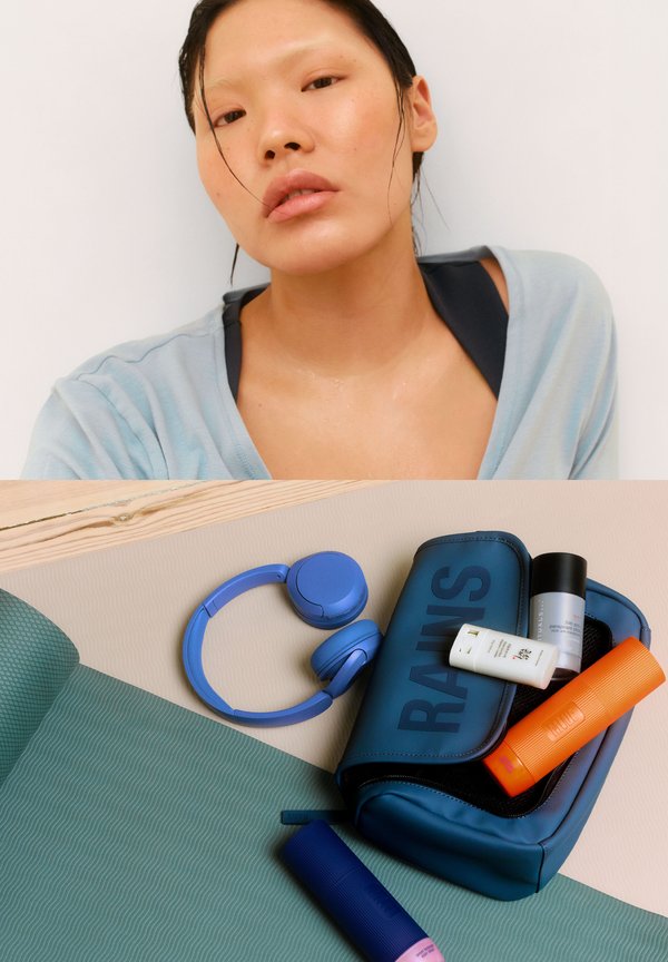 Bolsa impermeable azul con texto "RAINS", que contiene tres productos de cuidado de la piel coloridos. Incluye auriculares azules sobre una alfombra verde texturizada.