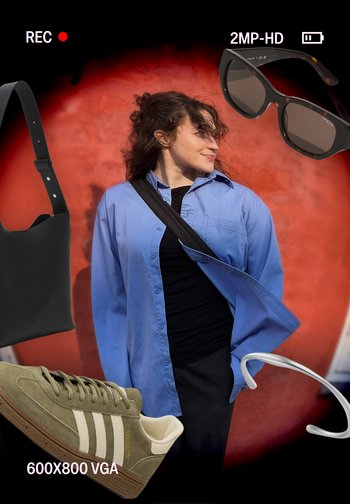 Chemise oversize bleu clair, haut noir, sac bandoulière noir, baskets en suède vert olive avec rayures blanches, lunettes de soleil noires surdimensionnées et écouteurs.