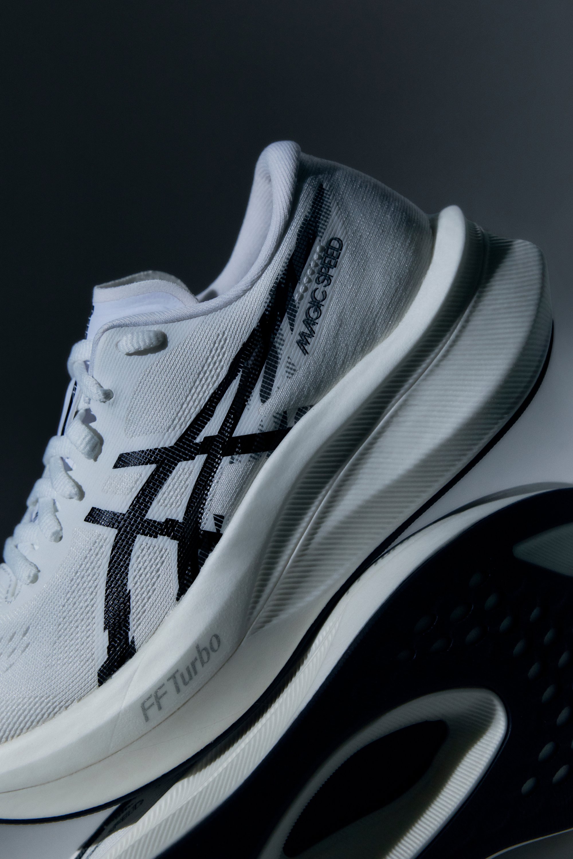 Weißer Sportschuh mit einem strukturierten Strick-Obermaterial, das schwarze Akzentstreifen und die „MAGIC SPEED“-Marke trägt; gepolsterte Sohle mit schwarzen Gummidetails.