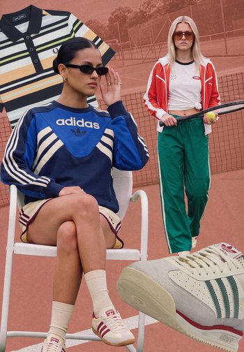 Donna con felpa blu Adidas e pantaloncini seduta su una sedia con occhiali da sole; un'altra donna in piedi con racchetta da tennis su un campo in terra rossa.