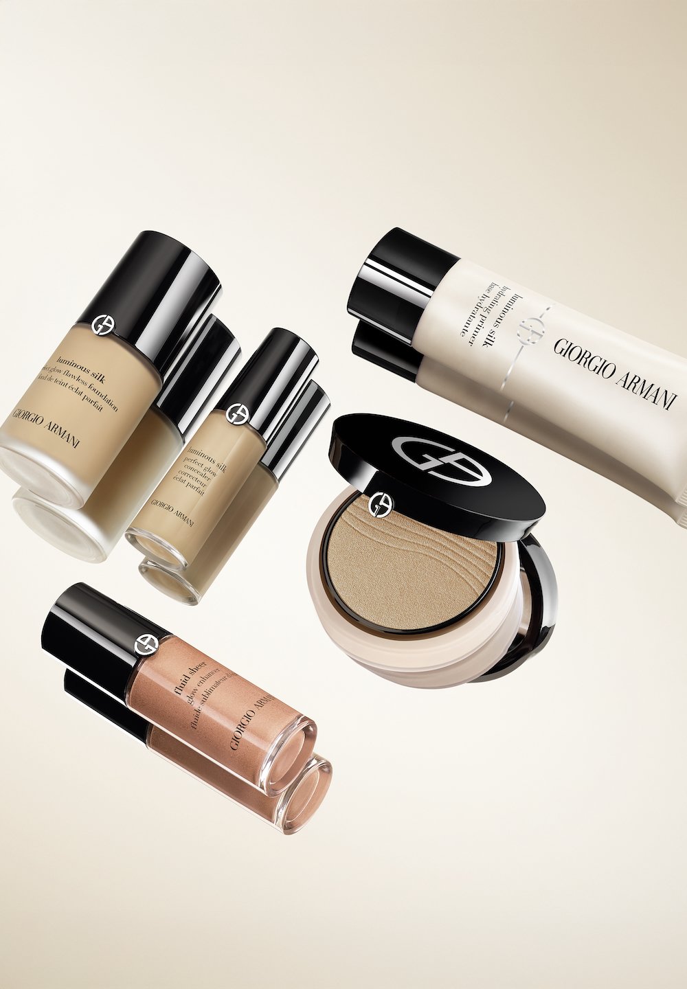 Fem Giorgio Armani sminkprodukter med glas- och plastbehållare. Färgerna varierar från beige till brunt. Framträdande svarta och silveraccenter.