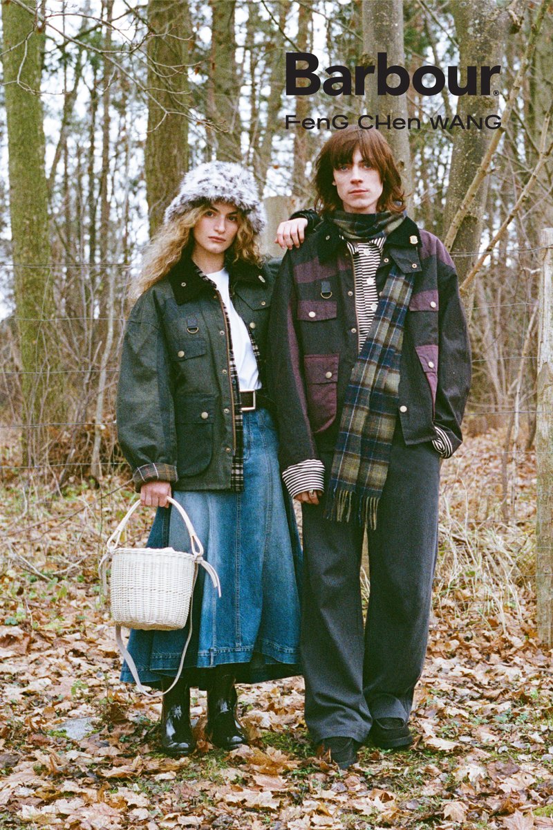 Twee mensen in herfstkleding staan in een met bladeren bedekt bos, de ene draagt een bontmuts en houdt een witte rieten tas vast, de ander heeft een geruite sjaal om.