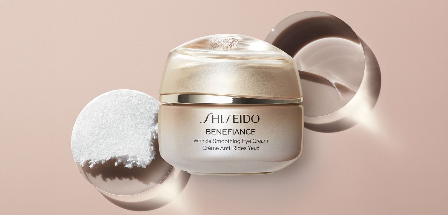 Słoik kremu pod oczy Shiseido Benefiance Wrinkle Smoothing z kremową konsystencją na okrągłej, refleksyjnej powierzchni na beżowym tle.