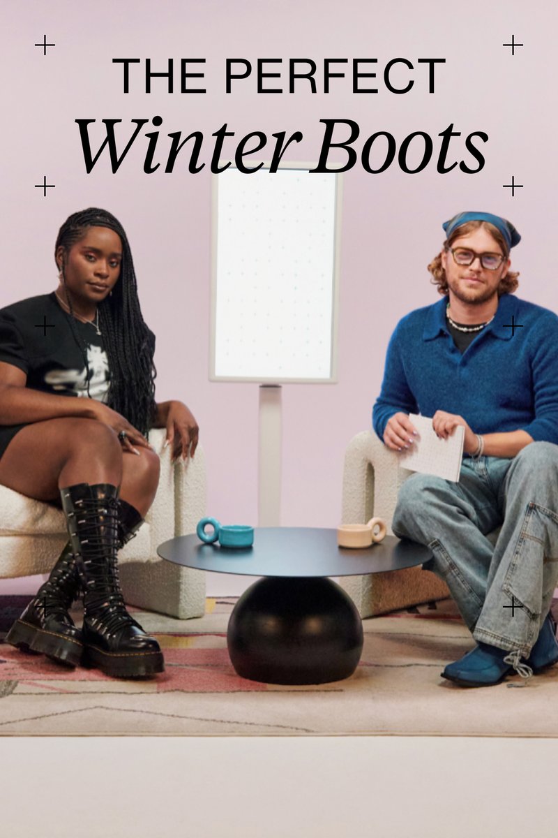 Eine Frau und ein Mann sitzen auf stilvollen Stühlen neben einem runden Tisch mit Bechern und betonen die Wintermode in einem modernen, pastellfarbenen Ambiente.