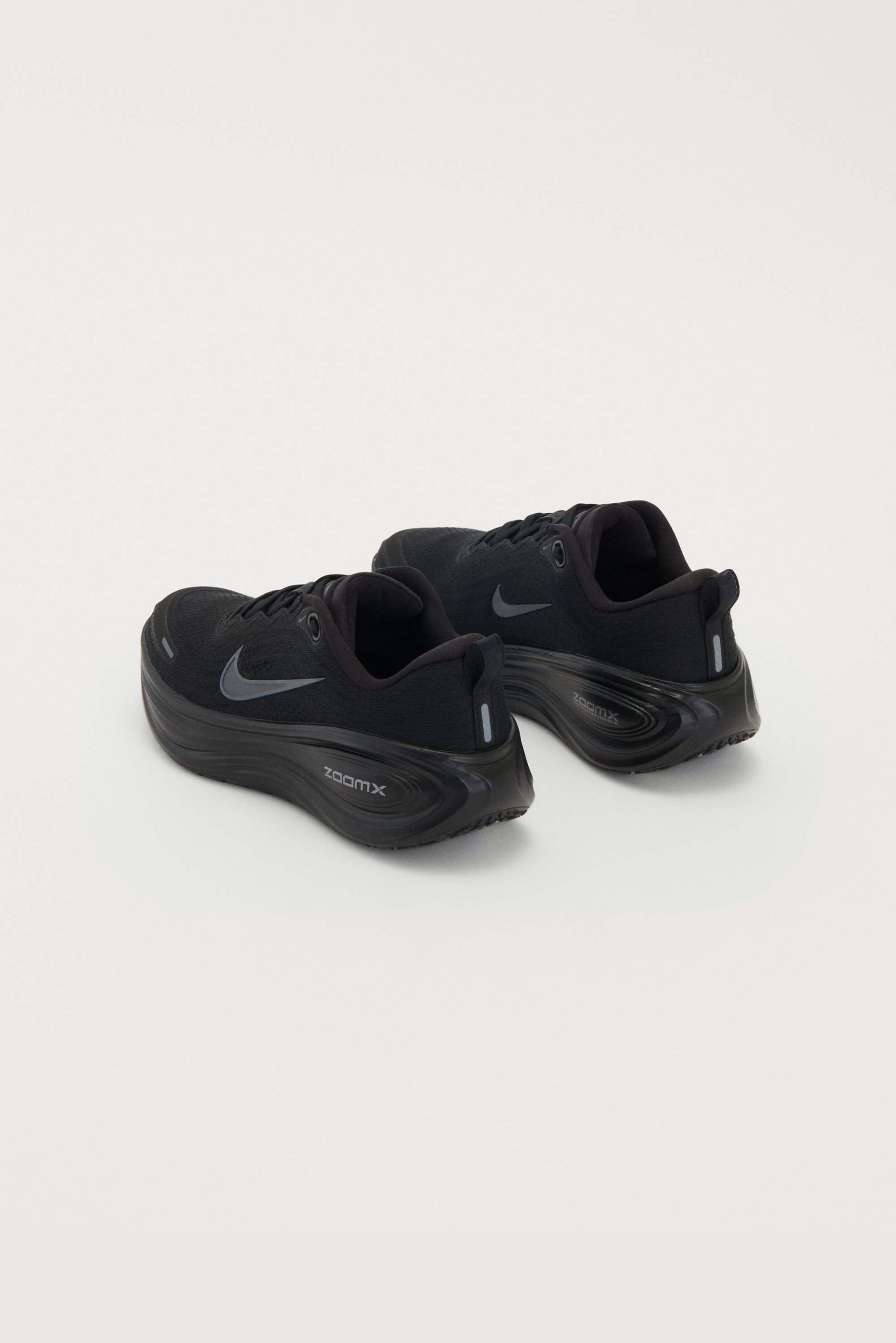 Zwarte Nike sneakers met een mesh bovenwerk, ronde vorm en gevoerde zolen met de "zoomx" branding op de zijkant.