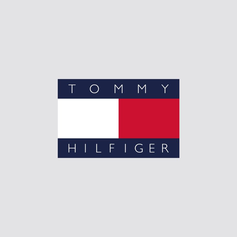 Logotipo de Tommy Hilfiger que presenta un fondo azul marino con texto en negrita y rectángulos en rojo, blanco y azul. Simboliza la herencia y el estilo americano.
