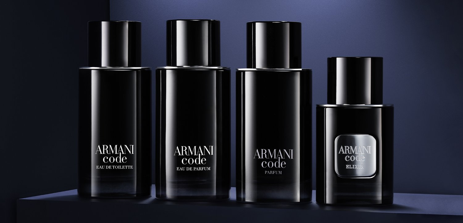 Quatre flacons noirs de parfum Armani Code de tailles variées, étiquetés Eau de Toilette, Eau de Parfum, Parfum et Elixir, sur une surface sombre.