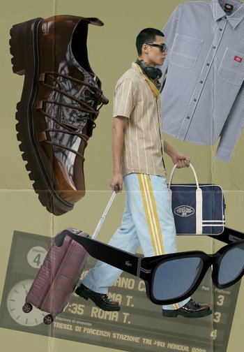 Homme en chemise rayée et pantalon bleu clair tirant une valise rose, entouré de chaussures marron, chemise rayée, sac bleu et lunettes de soleil noires.
