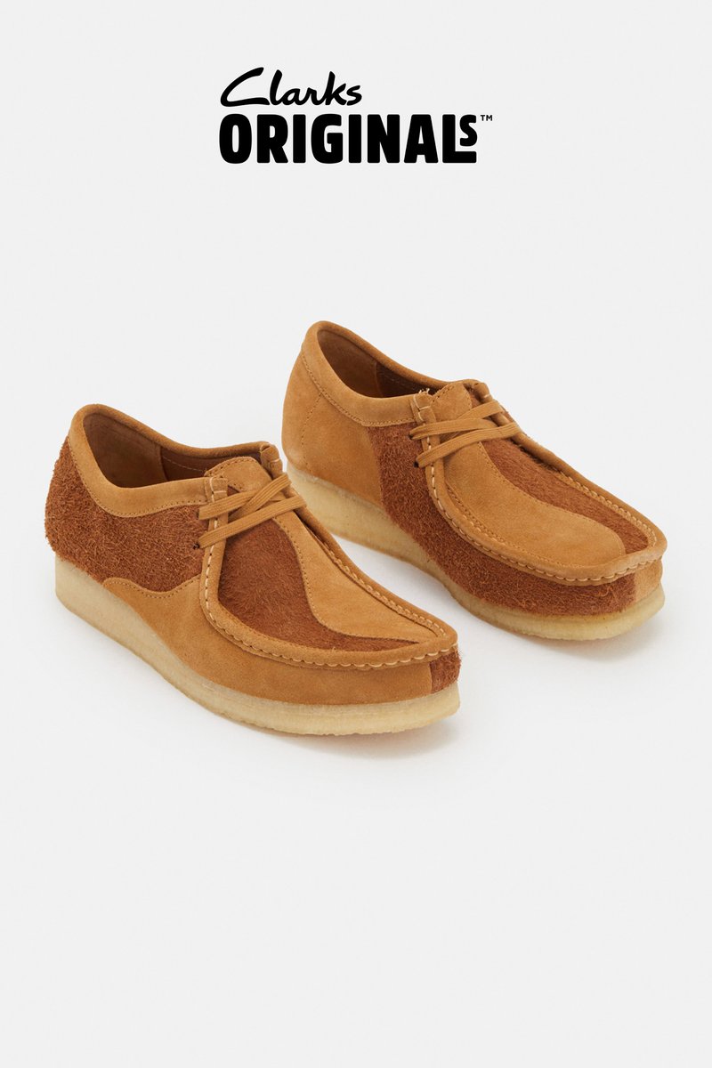 Zapatos de ante marrón claro con un panel lateral texturizado y un diseño de cordones, exhibidos sobre un fondo blanco liso. Marca en la esquina superior.