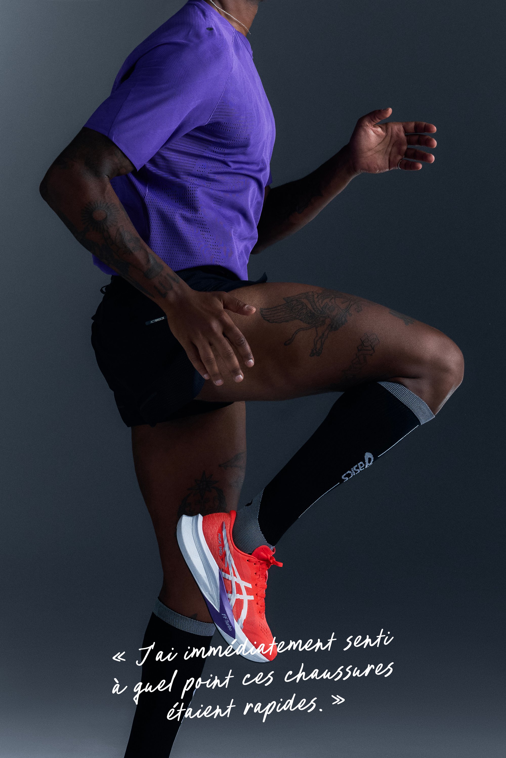 Athlète en t-shirt violet, shorts noirs et chaussettes hautes noires lève la jambe, portant des chaussures de course rouges et blanches vives sur fond sombre.