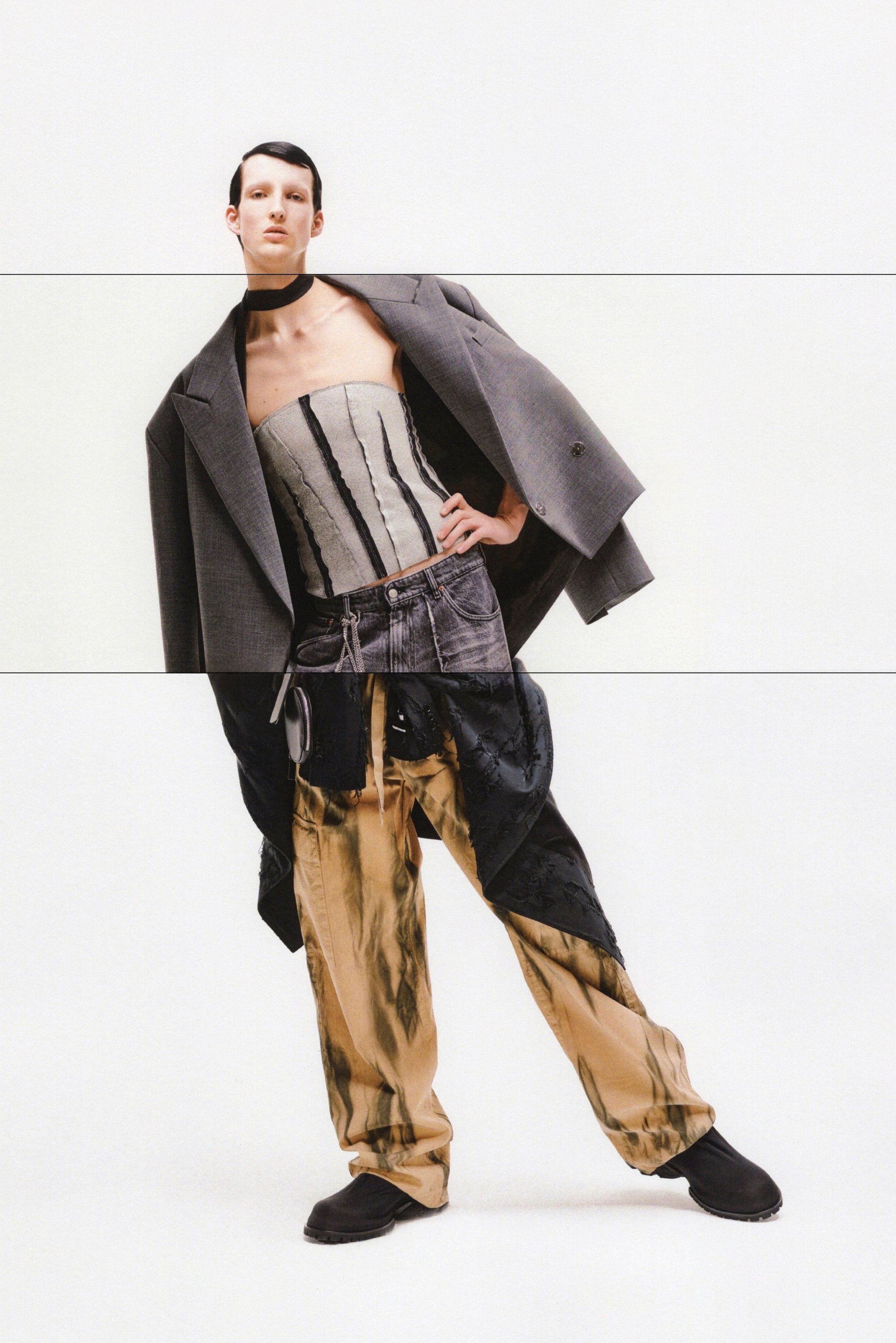 Blazer gris de gran tamaño, top de corsé a rayas, vaqueros oscuros desgastados y pantalones cargo con patrón metálico. Zapatos negros completan el conjunto.