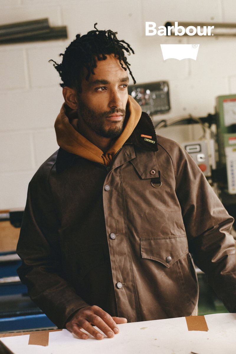 Bruine gewaaxte jas met een corduroy kraag, voorzien van drukknoopsluiting en een borstzak. Draag deze over een gele hoodie.