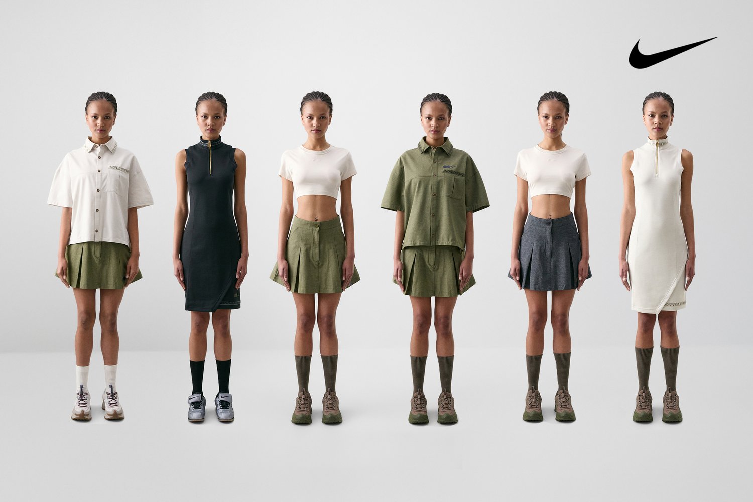 Seis modelos están alineados, mostrando varios conjuntos de Nike, incluyendo faldas y vestidos, combinados con zapatillas y calcetas hasta la rodilla.