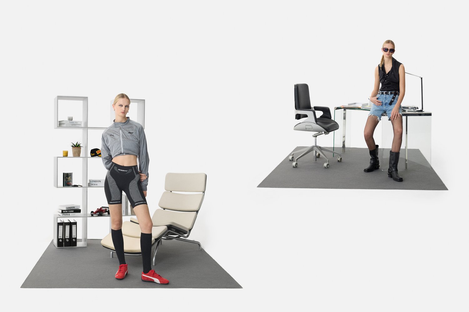 Chaqueta gris, pantalones cortos deportivos negros con detalles de malla, zapatos rojos. Silla blanca, escritorio de vidrio con silla de oficina negra, suelo gris, decoración minimalista.